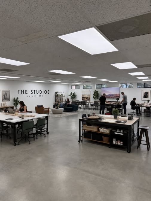 Members working at large tables on the open studio floor